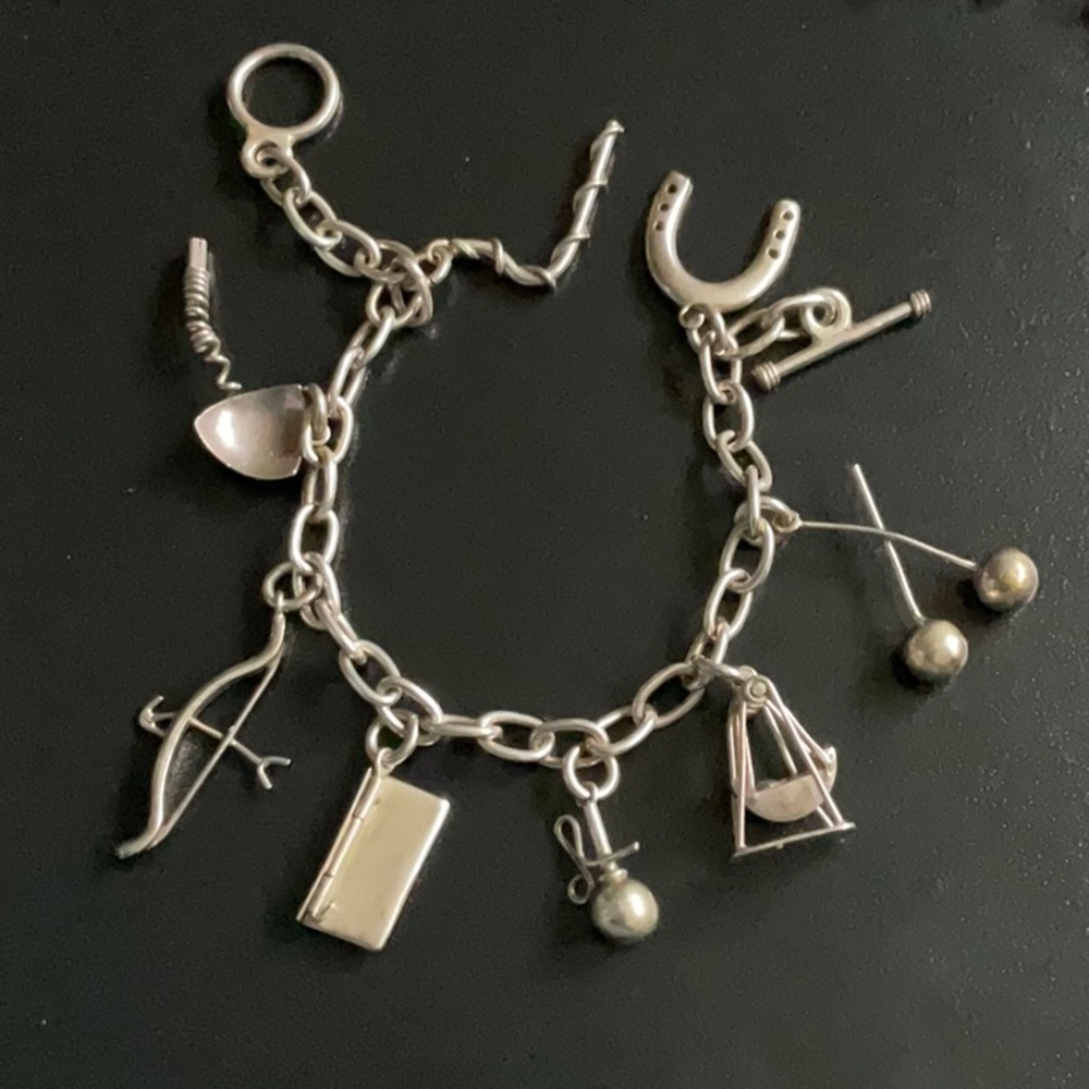 Vintage silver tone charm bracelet  8” horseshoe, letter, oil rig, bow, bola